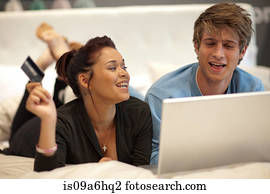 Couple shopping online in bed