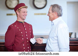 Older man tipping bellhop in lobby