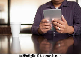 Mid adult man using digital tablet