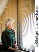 Senior woman looking through window Senior woman looking through window