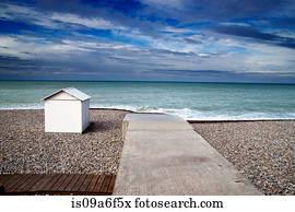 White beach hut on shingle beach