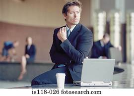 Businessman outside with laptop 