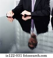 Reflection of a businessman on a shiny black desk