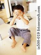 Boy with hands over eyes