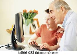 Grandfather and grandson using computer