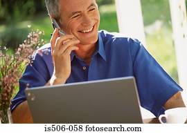Man using laptop computer and cellphone Man using laptop computer and cellphone