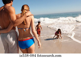 Parents watching children play on a beach