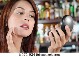 Woman using hand mirror