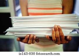 Woman carrying stack of paper