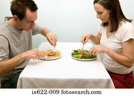 Couple eating contrasting meals