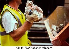 Construction worker holding rubble