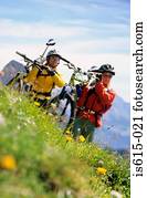Carrying bikes across hillside.