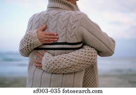 Rear view of couple hugging on beach