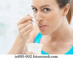 mulher jovem, comer, iogurte