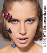 Woman with butterflies on her face