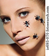 Woman with plastic flies on her face