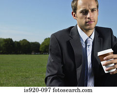 Serious looking businessman in a park