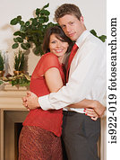 Couple hugging by fireplace
