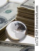 Silver globe and stacks of dollars