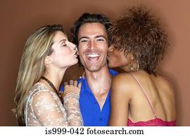 Man being kissed by two women