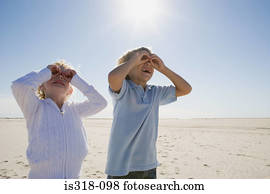 Boy and girl looking through hands