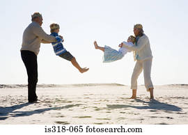 Grandparents playing with grandchildren on beach