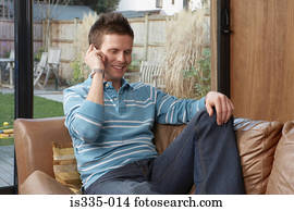 Man using a cellular telephone on sofa