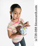 Girl putting money in piggy bank