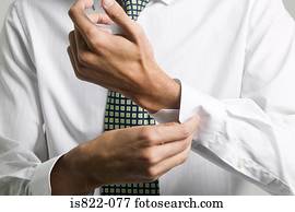 Man buttoning cuff of his shirt