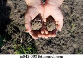Child with handfuls of soil