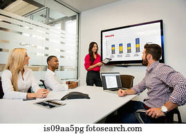 Young business colleagues looking at digital table in meeting in conference room