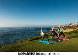 Women on cliff, in yoga position