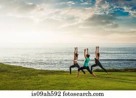 Women on cliff, in yoga position
