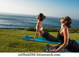 Women on cliff, in yoga position