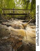 Young man on river footbridge, Naramata, British Columbia, Canada