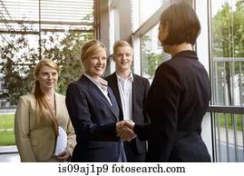 Business team greeting young female colleague