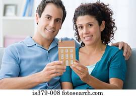 Couple holding a model of a house