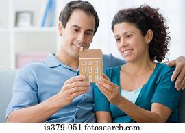Couple holding a model of a house