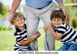 Boys grabbing fathers legs