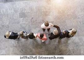 Overhead view of business team congratulating colleague