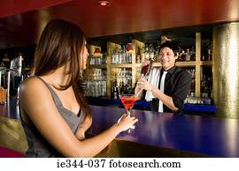 A woman getting served at a bar