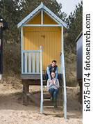 Couple sitting on steps of a beach hut
