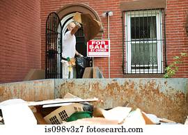 Man filling skip with rubble