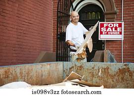 Man filling skip with rubble