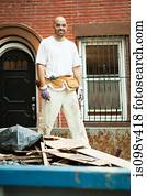 Man filling skip with rubble