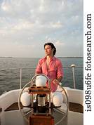 Mid adult man steering yacht