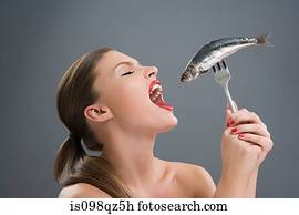 Woman holding a fish on a fork