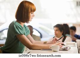 Woman using a cellular telephone in cafe