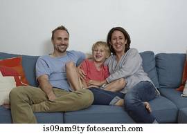 Parents with son sitting on sofa