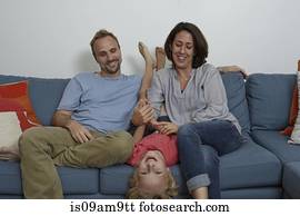 Parents with son sitting on sofa